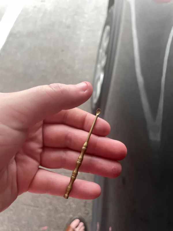 Tiny spoon in hand. Tire in background