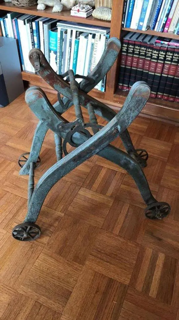 Rusted old metal base. Wood floor and books in the background.